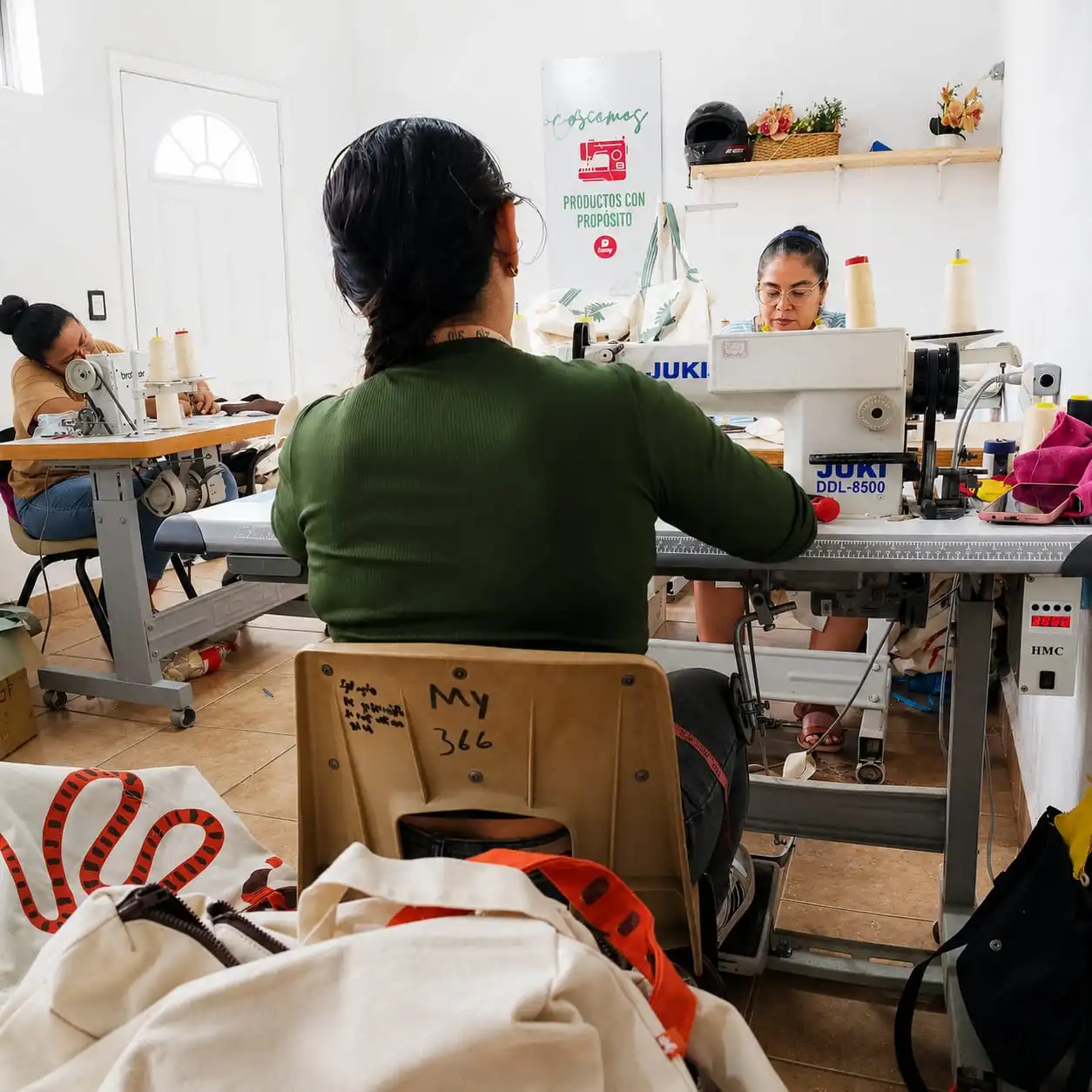 Manos trabajando en una estación de costura del taller de Cousy Nicaragua